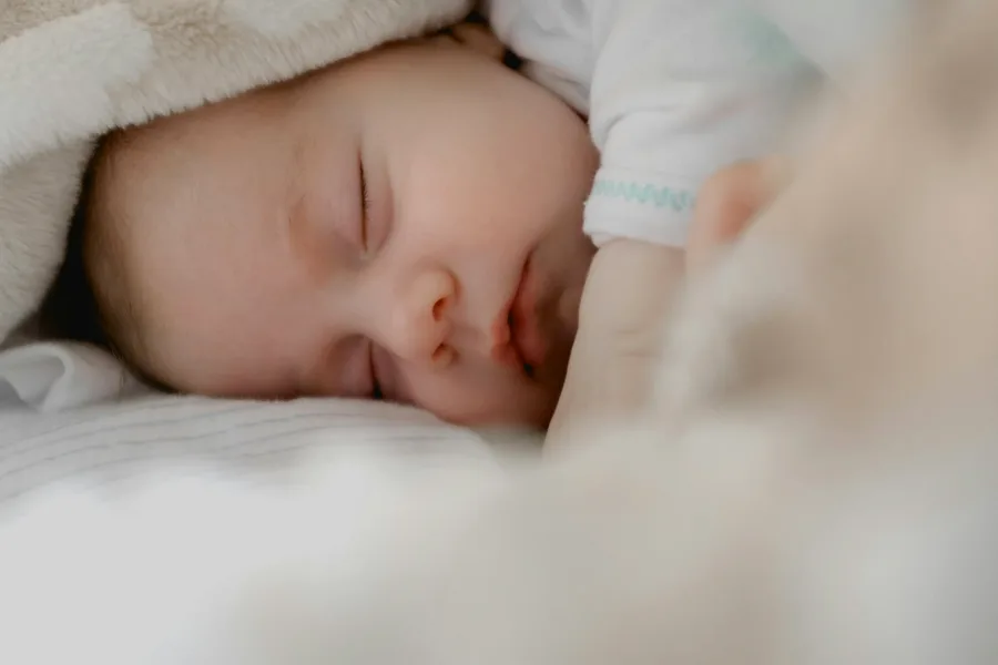 Sleep Training Survival Guide bedtime nursery setting with warm ambient nightlight and digital tablet